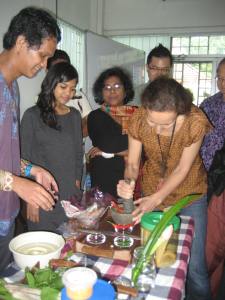 Lawrence having a go at making sambal belacan with the other volunteers waiting their turn.