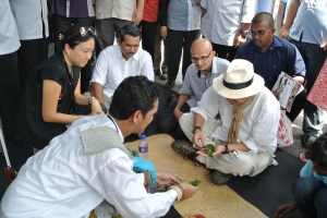 Dato' Nazri rolling up a sireh quid with Dato' Ibrahim looking on