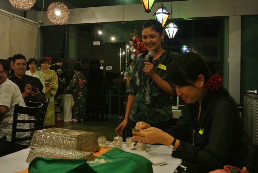 Zahara explaining how to roll a quid with the help of Karen