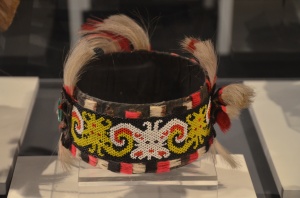 This headdress is worn by the women of Dayak Kenyah. It is decorated by yellow and white beads in the motif of ancestral spirits. It is also decorated with white horse hair at the top.
